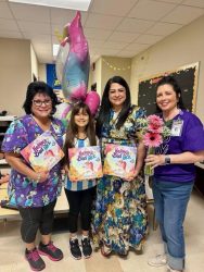 Ximena and staff holding her book