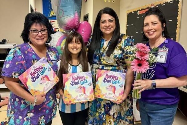 Ximena and staff holding her book