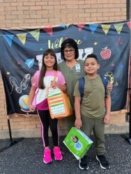 Ximena, her brother and a school employee smiling